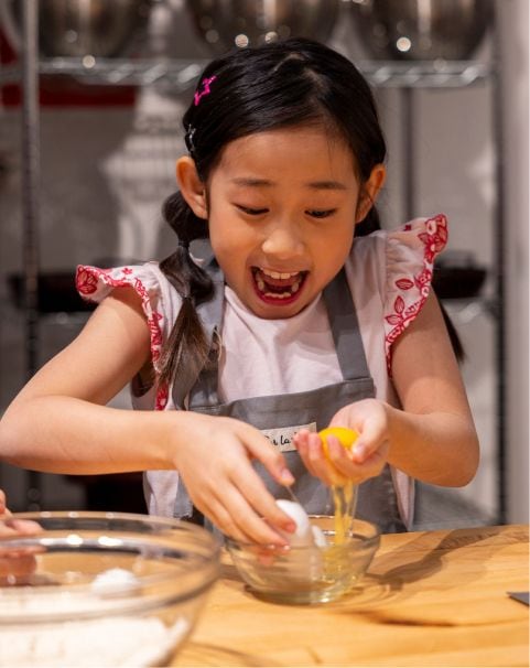 Girl separating eggs in Sur La Table kitchen