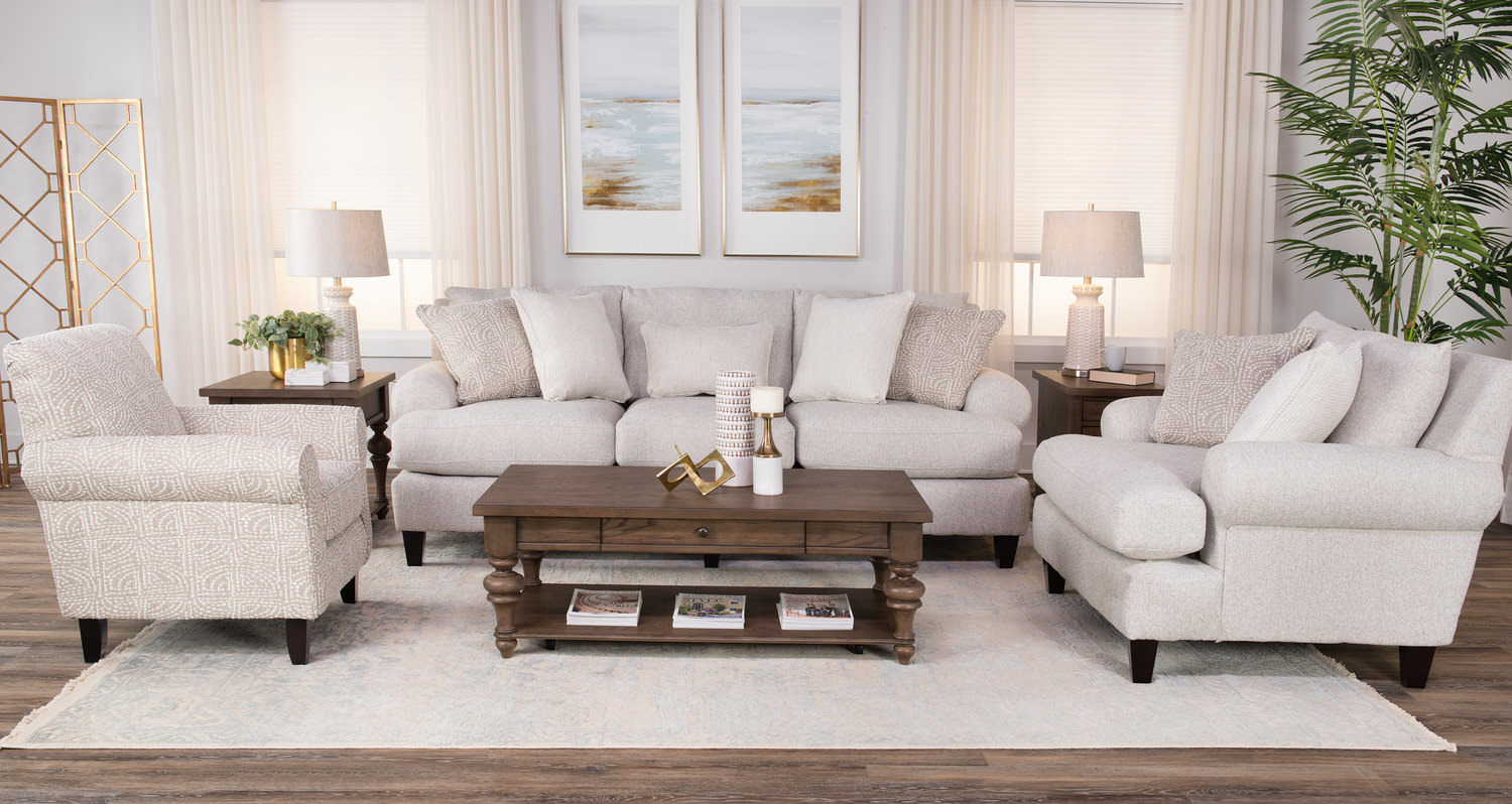 Elegant living room with white sofas, wooden coffee table, lamps, and coastal view