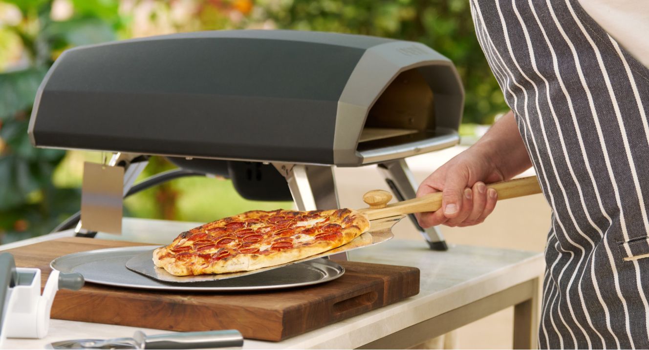 Ooni pizza oven outdoors with fresh pepperoni pizza