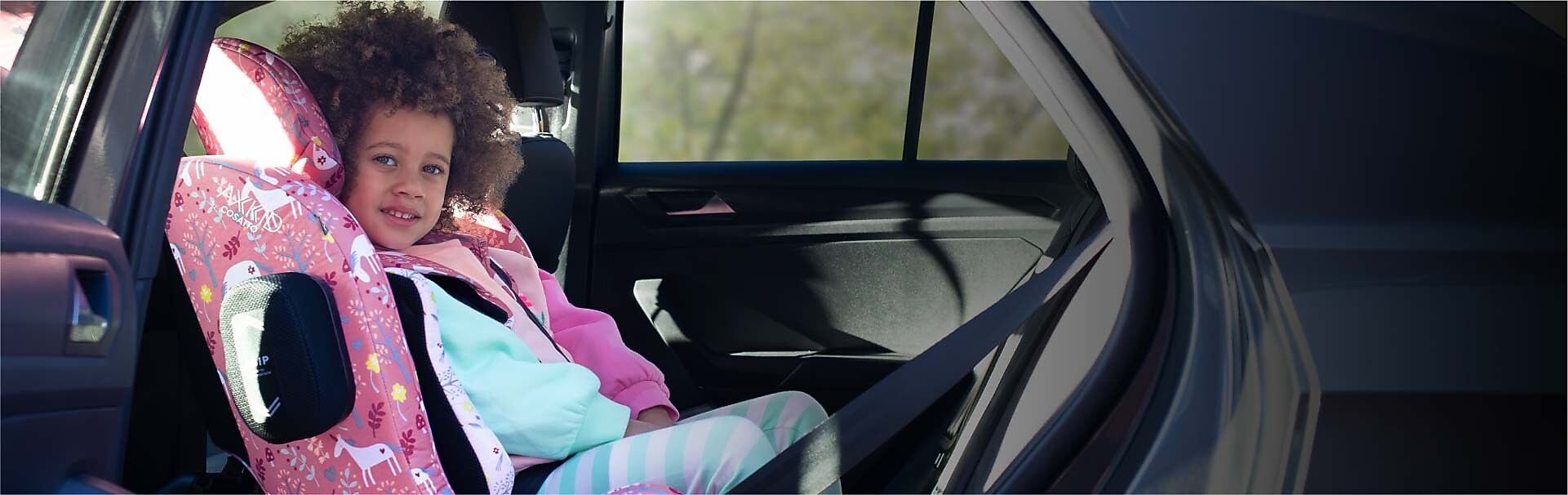 Two car seats next to eachother. One with fabric in pink and the other in blue/green.