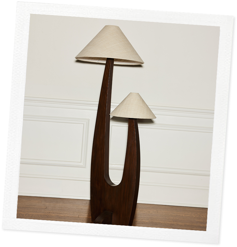 A tilted photo of a unique dual-lamp with a wooden base and two angular shades