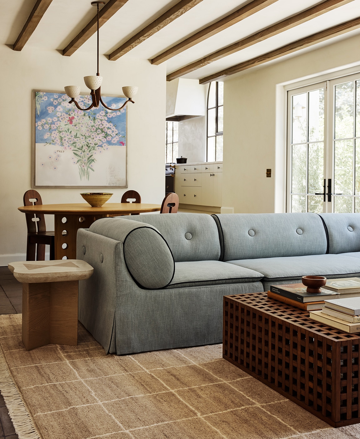 Stylish living room with a blue sofa, wooden furniture, and large windows