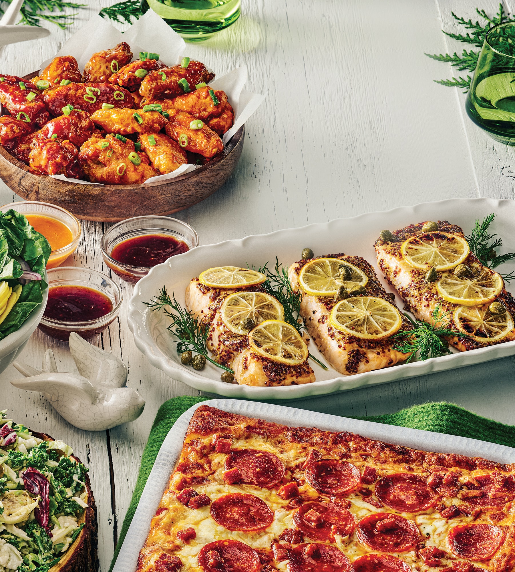 Table avec divers plats: pizza, poulet grillé, salades, pour une publicité de restaurant