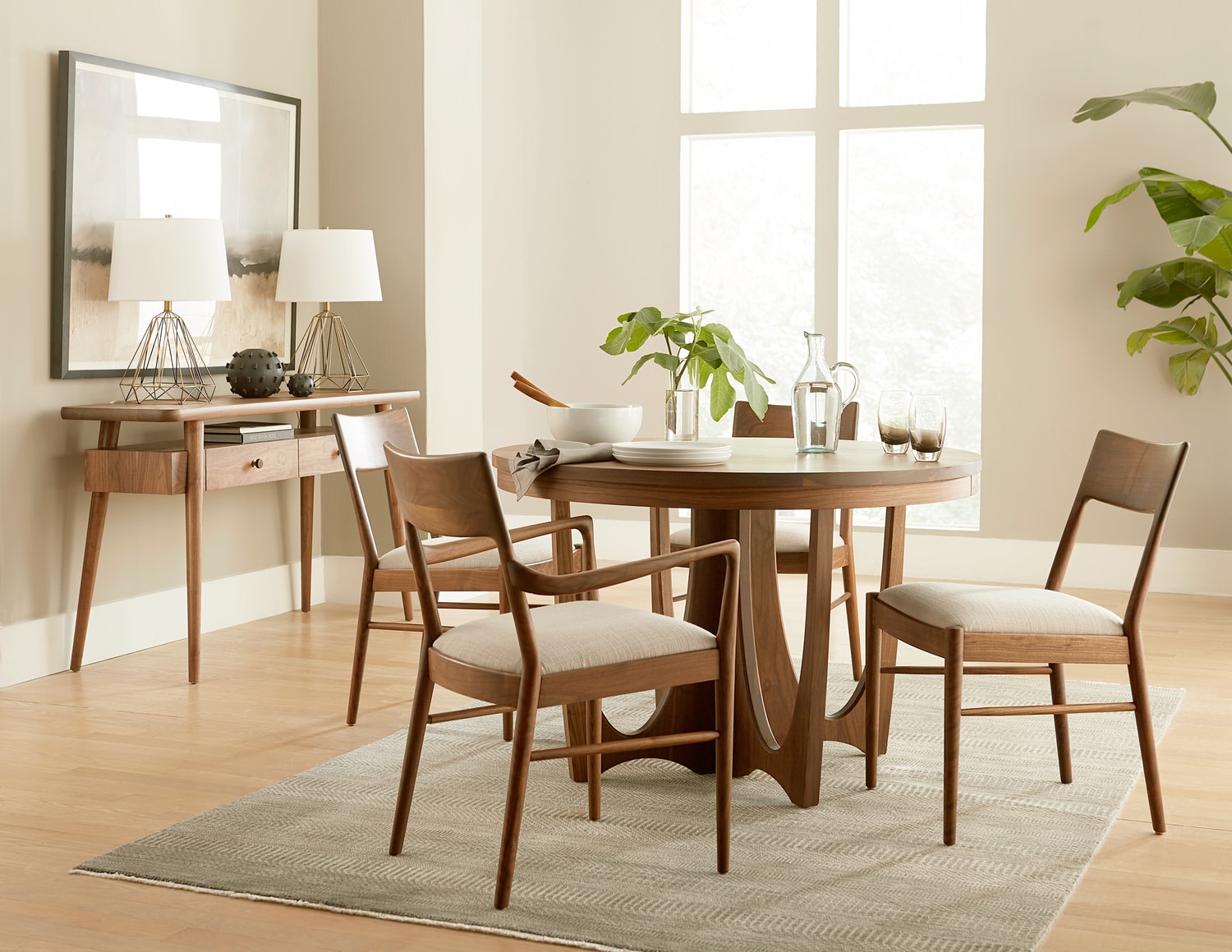 Modern dining room with a wooden table, four chairs, and stylish decor in a bright, airy space