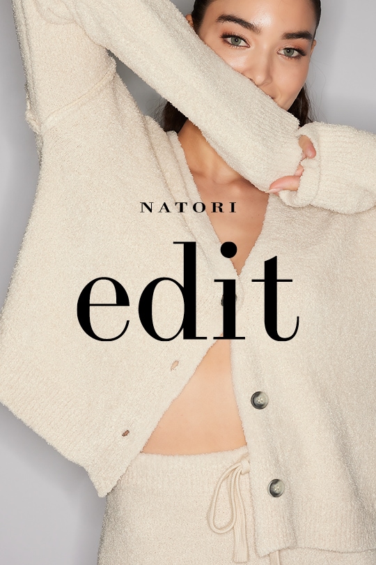 Woman in beige cardigan smiling, covering mouth with sleeve, text "Natori edit" overlaid