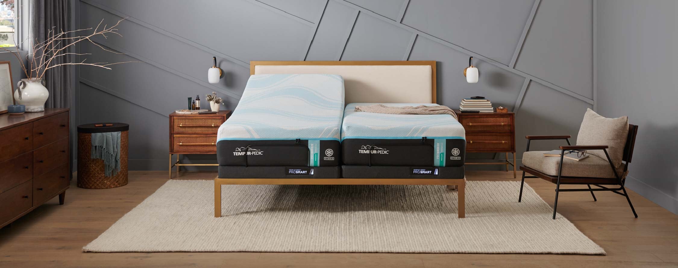 Modern bedroom with a layered adjustable mattress on a wooden bed frame, flanked by matching nightstands