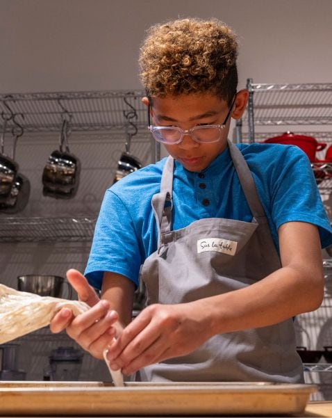 Teenage piping pastry dough in Sur La Table cooking class