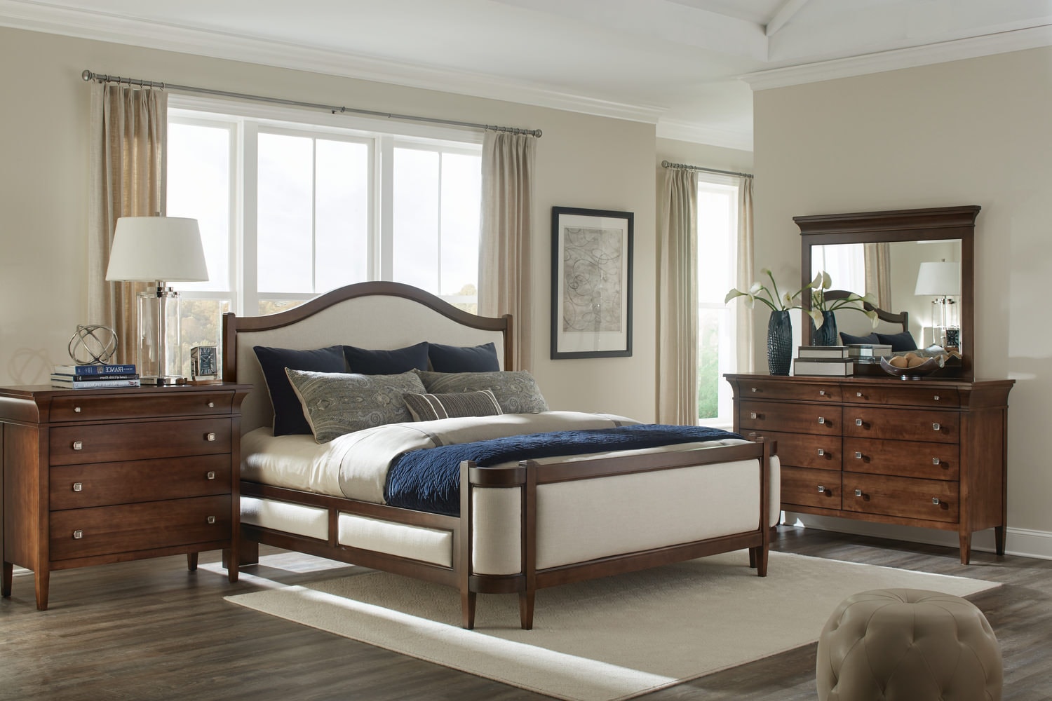 Elegant bedroom with a wooden bed, dresser, and nightstand, featuring neutral decor and natural light