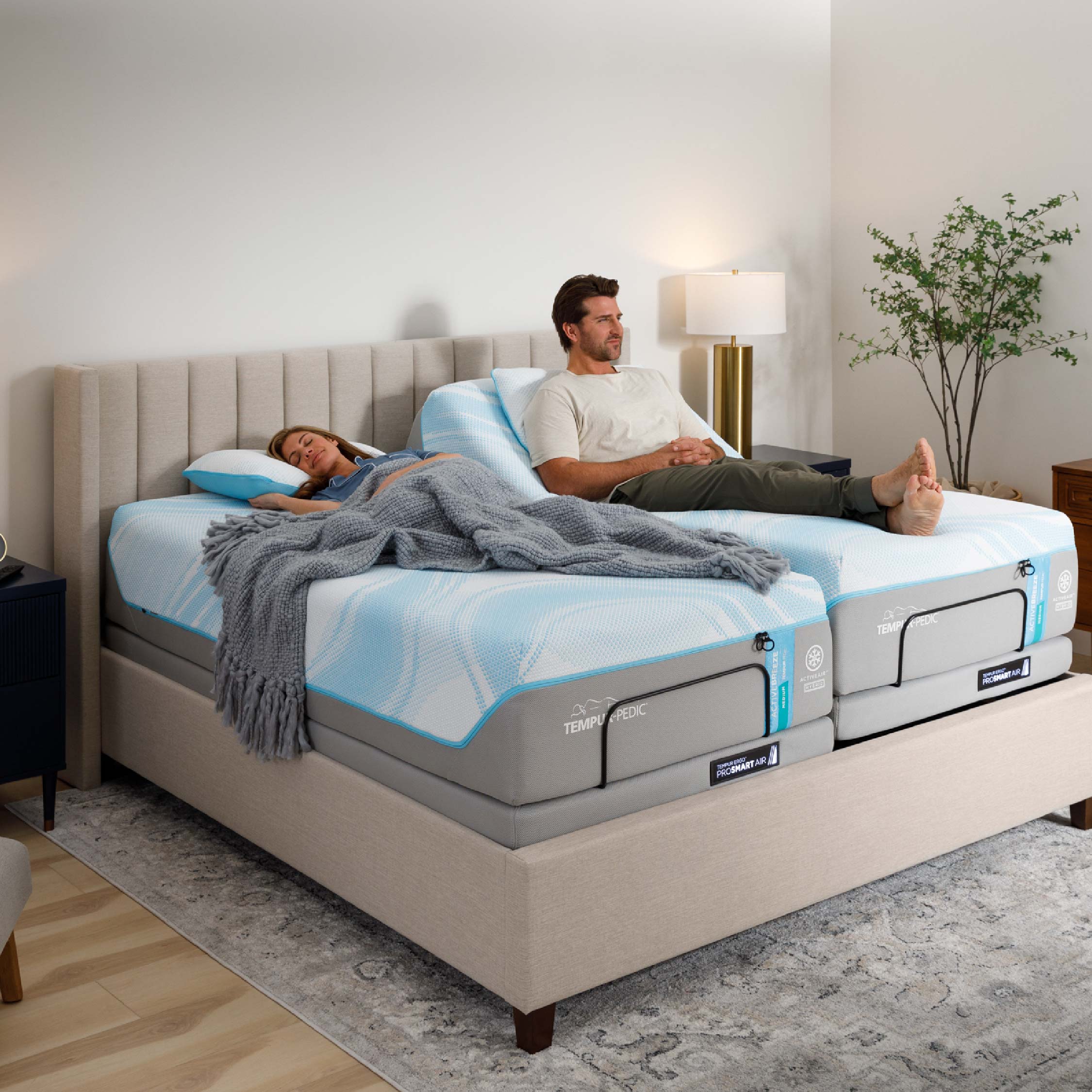 A couple in an adjustable bed, woman sleeping and man sitting up
