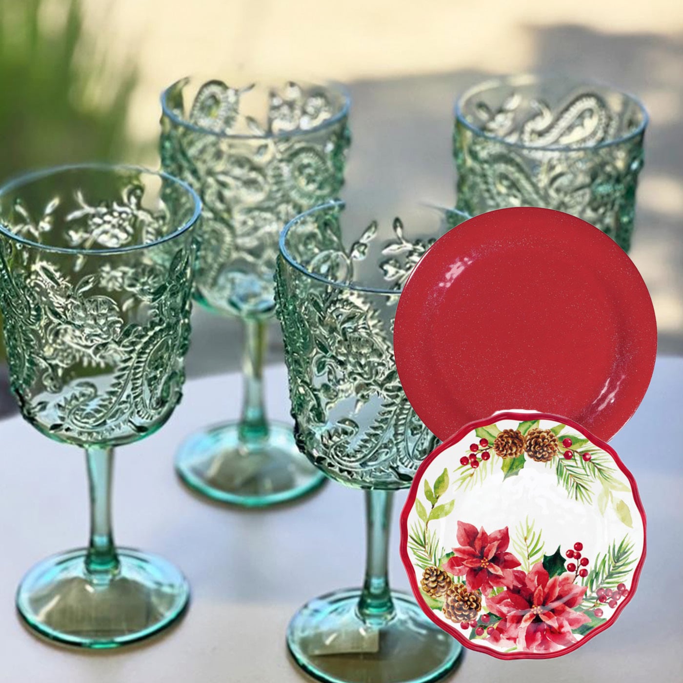 Four embossed teal wine glasses and two decorative plates with floral patterns