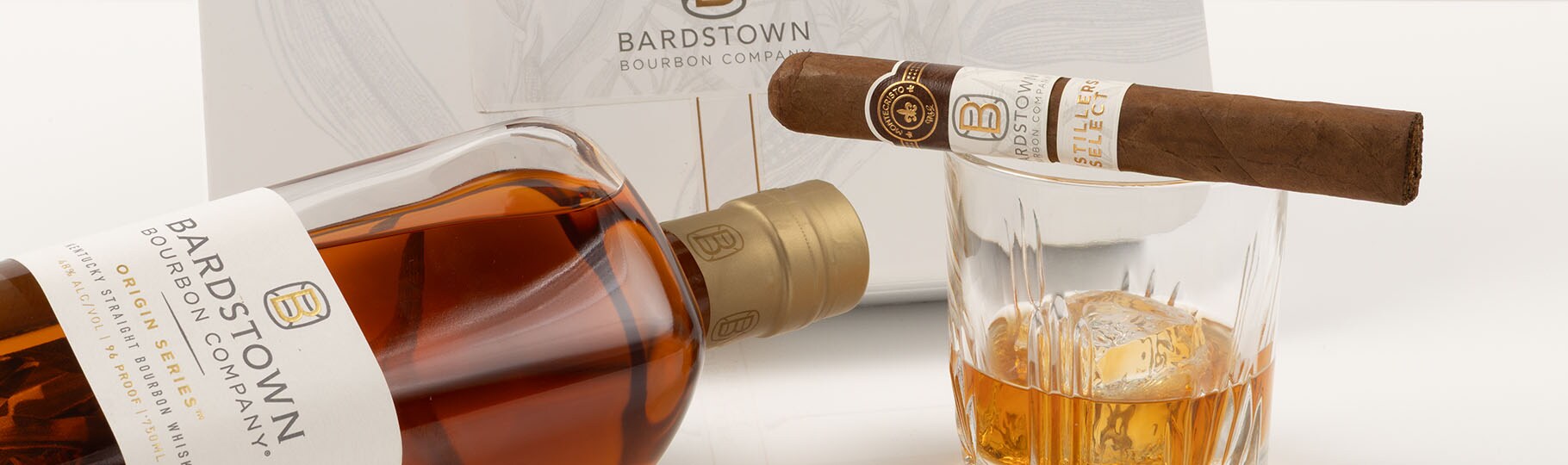 Bottle of Bardstown whiskey, glass with whiskey, Bardstown cigar on top of a glass