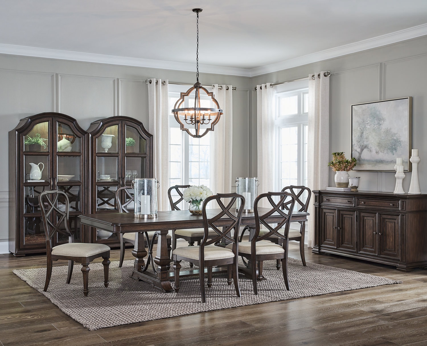 Elegant dining room with a wooden table, chairs, china cabinets, and a chandelier