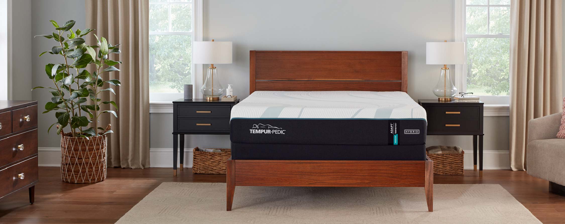 Modern bedroom with a wooden bed frame, mattress, two nightstands, and a decorative plant