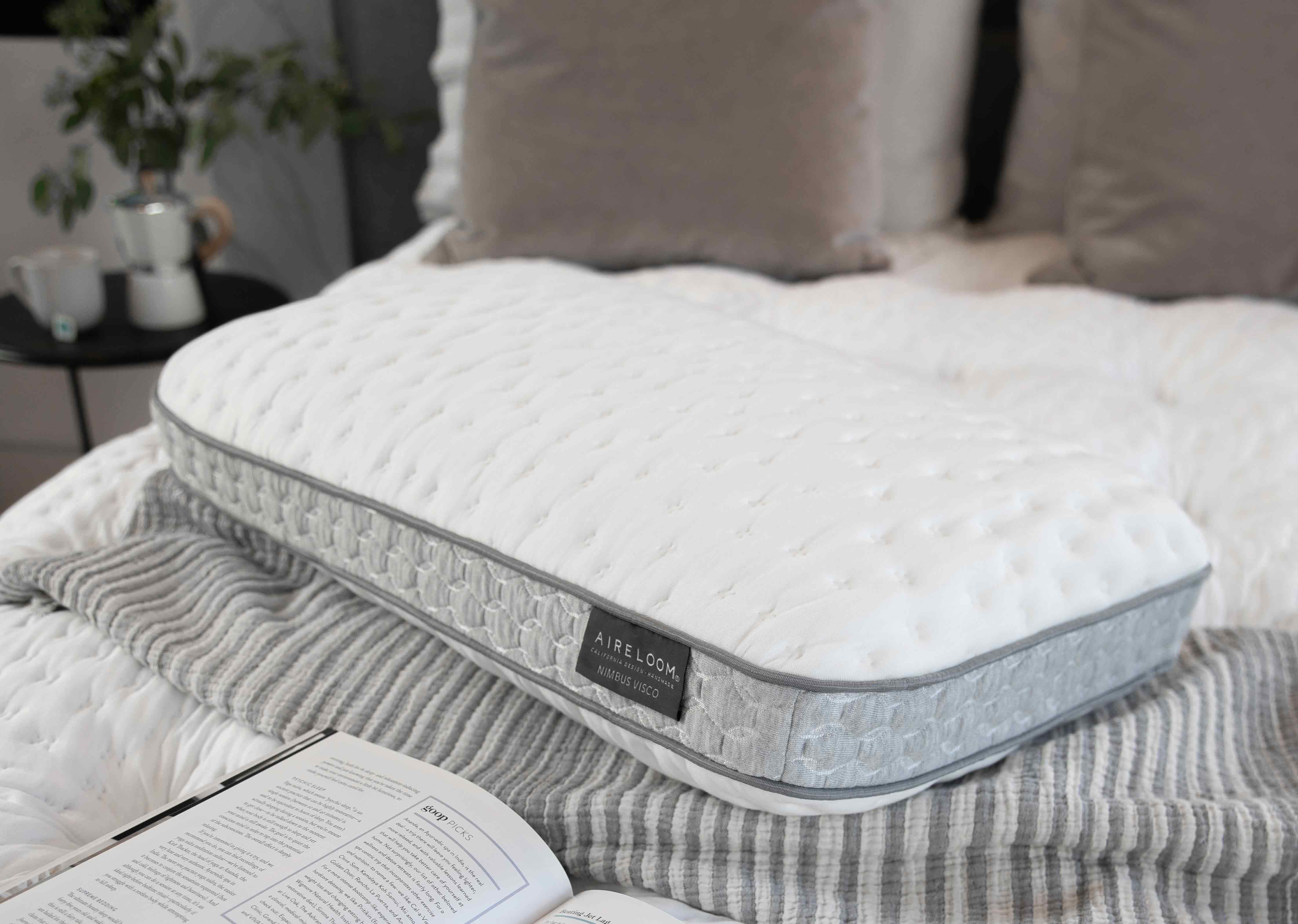 Orthopedic pillow on a striped bedspread in a cozy bedroom setting