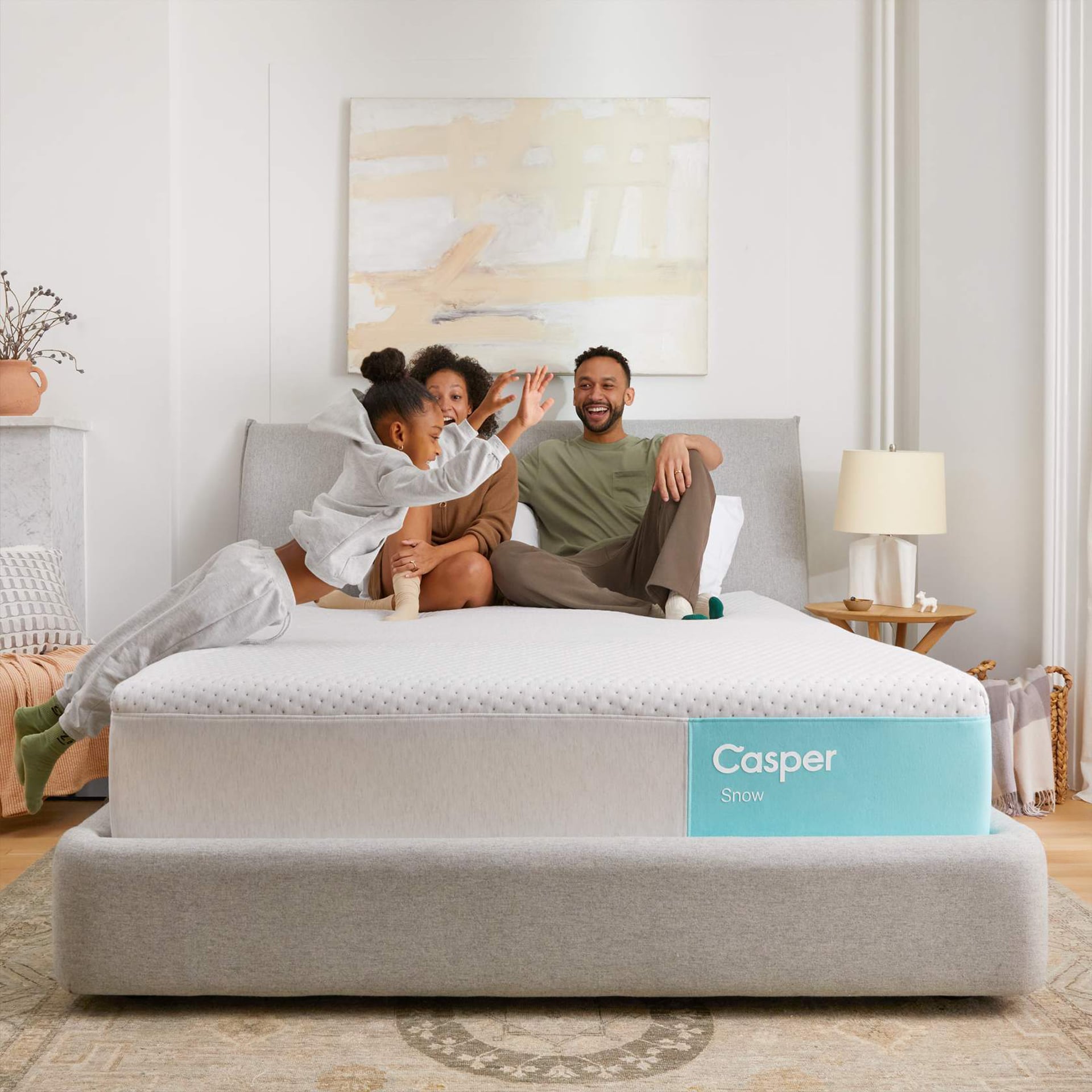 A couple relaxing on a Casper mattress in a well-decorated bedroom