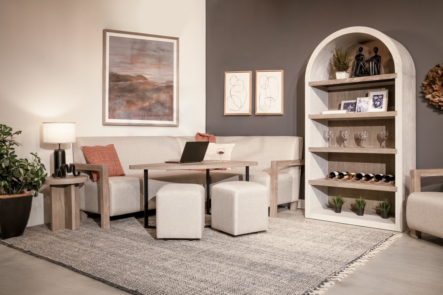 Modern living room with a desk, chairs, built-in shelves, and artworks