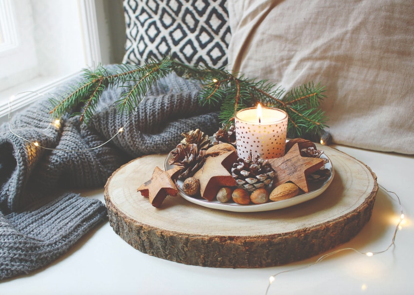 Festive candle centerpiece with natural decorations.