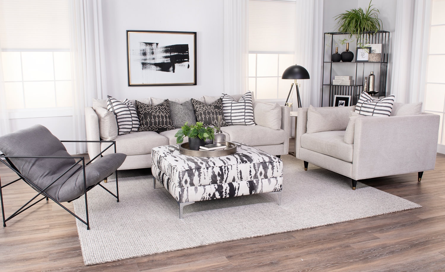 Modern living room with sofas, chairs, coffee table, and decorative shelving