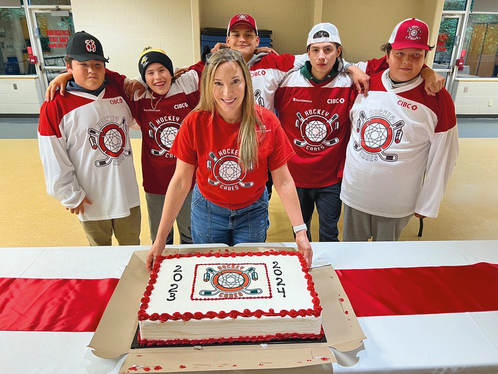 Groupe en uniforme rouge avec un gâteau décoré, célébration d'équipe sportive