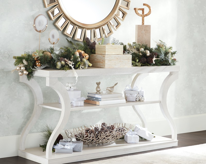 Elegant white console table decorated with holiday accents in a stylish room