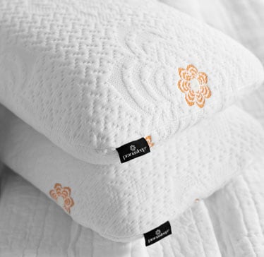 White textured pillows with floral embroidery and black tags