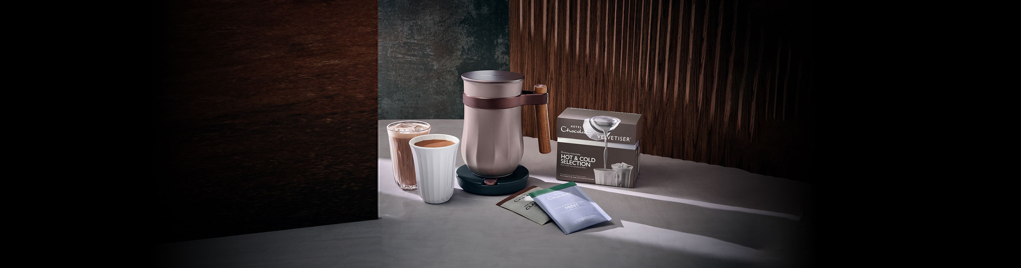 Cosmetics on a dresser in a dimly lit room with a wooden backdrop