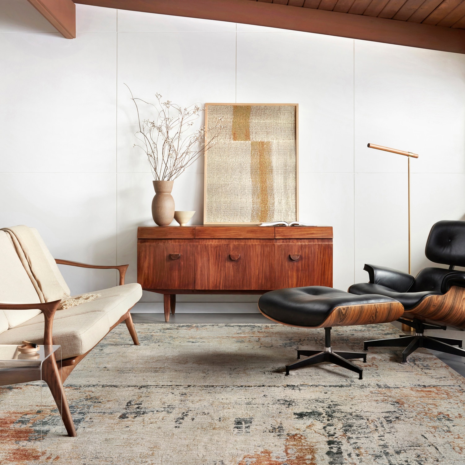 Modern living room with a wooden sideboard, Eames chair, and minimalist decor