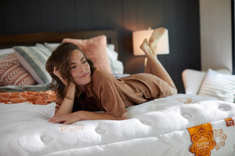 Woman lying on a bed, smiling, in a cozy bedroom setting