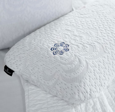 White textured pillow with embroidered blue flower design