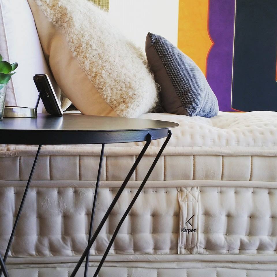 Cozy living room corner with a tufted sofa, colorful vertical wall art, pillows, and a small round table