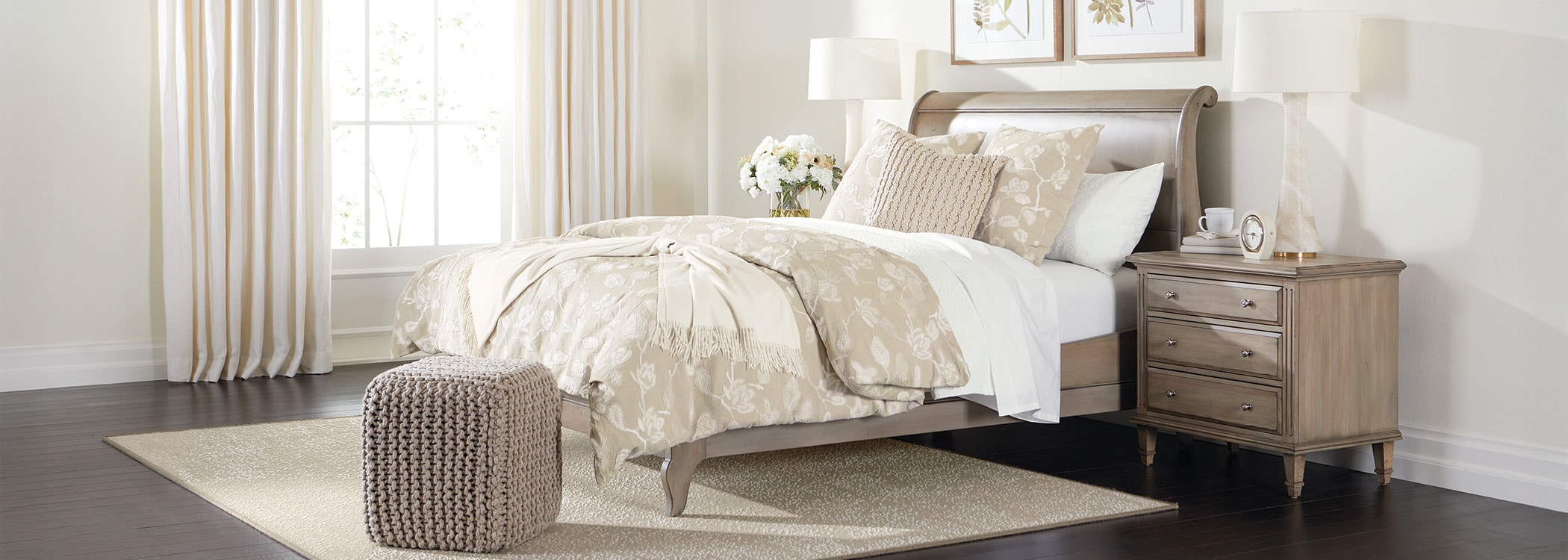 Elegantly styled bedroom with a beige color scheme, featuring a bed, nightstand, and curtains