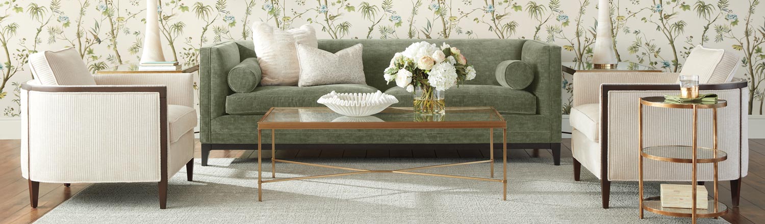 Elegant living room with a green sofa, wooden coffee table, and patterned wallpaper