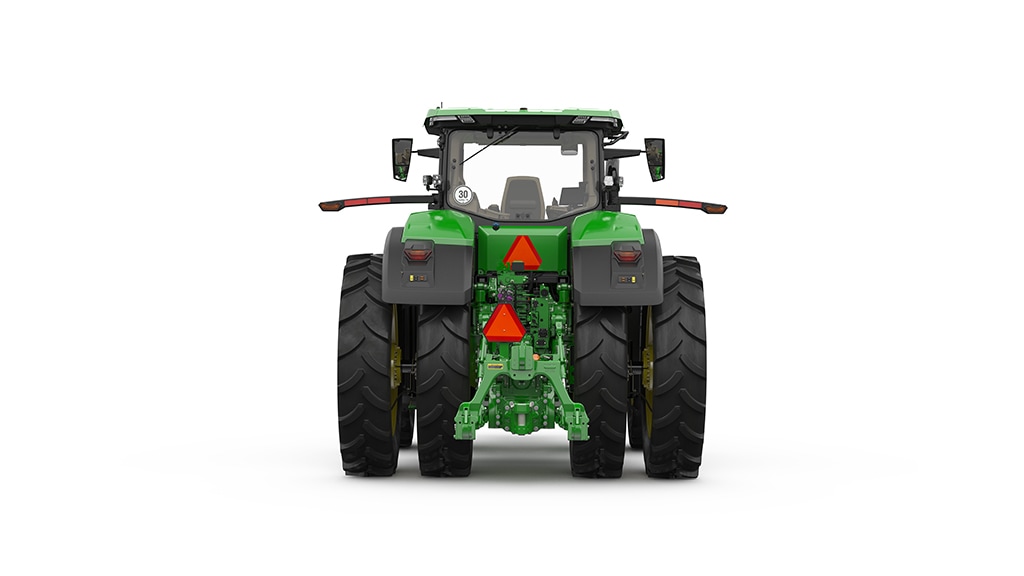 A green tractor decorated with red ribbons and a Christmas wreath