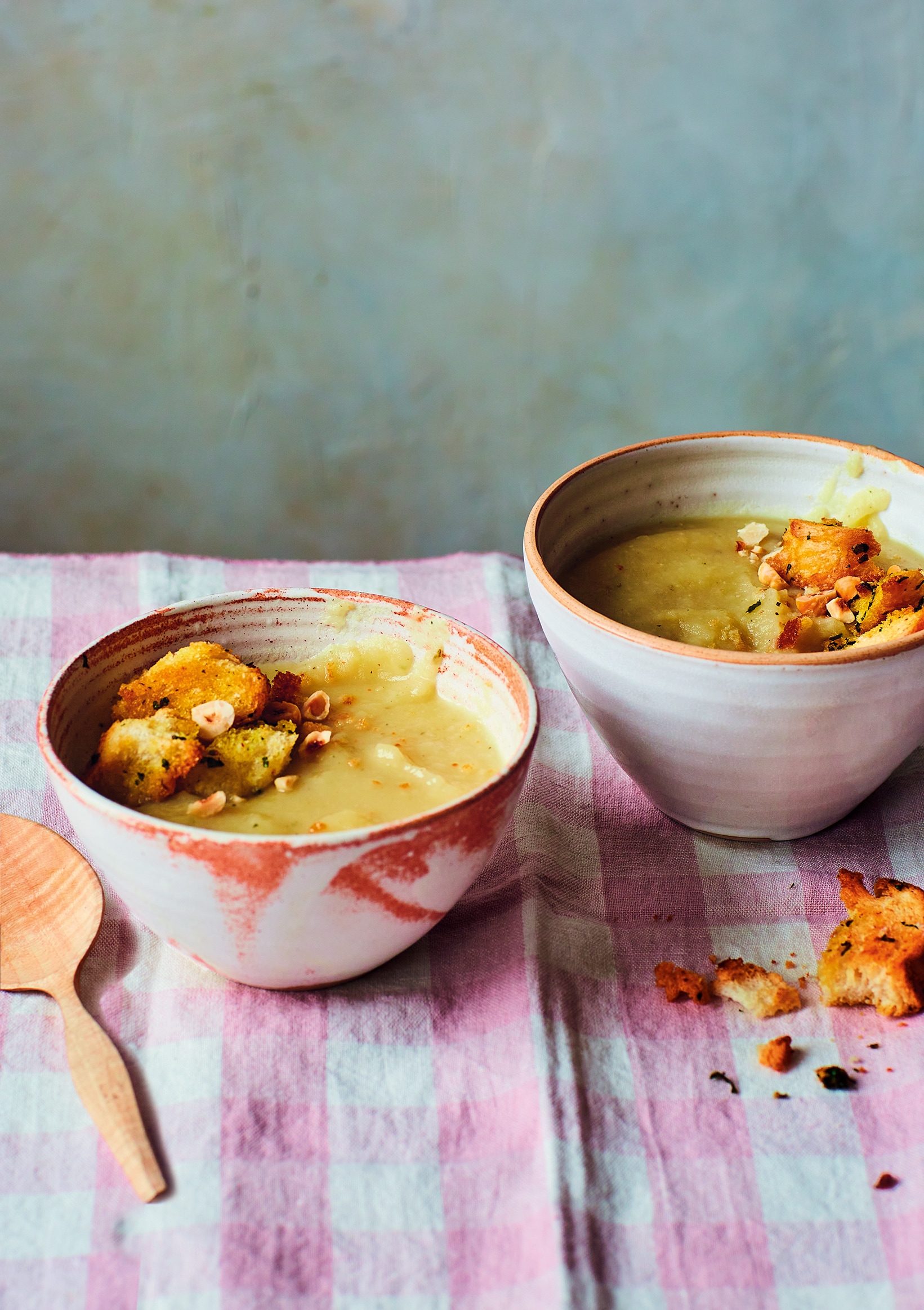 Soupe crémeuse servie dans deux bols en céramique sur une nappe rayée
