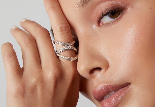 Close-up of a woman wearing elegant rings, hand on face
