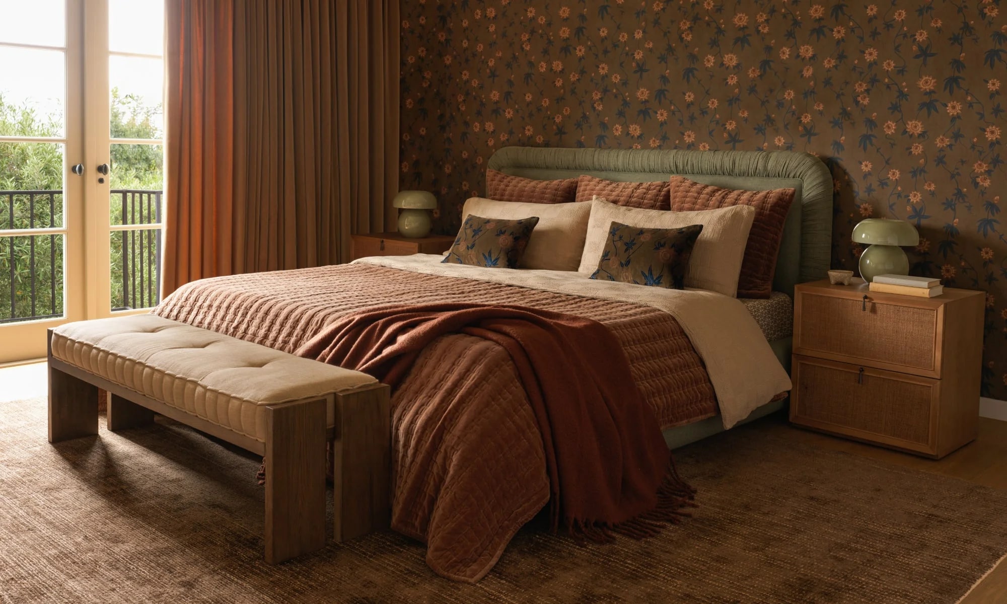 Elegant bedroom with a neatly made bed, striped and floral bedding, two bedside tables, and a view to the balcony