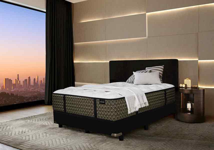 Modern bedroom with a large bed and city view at sunset