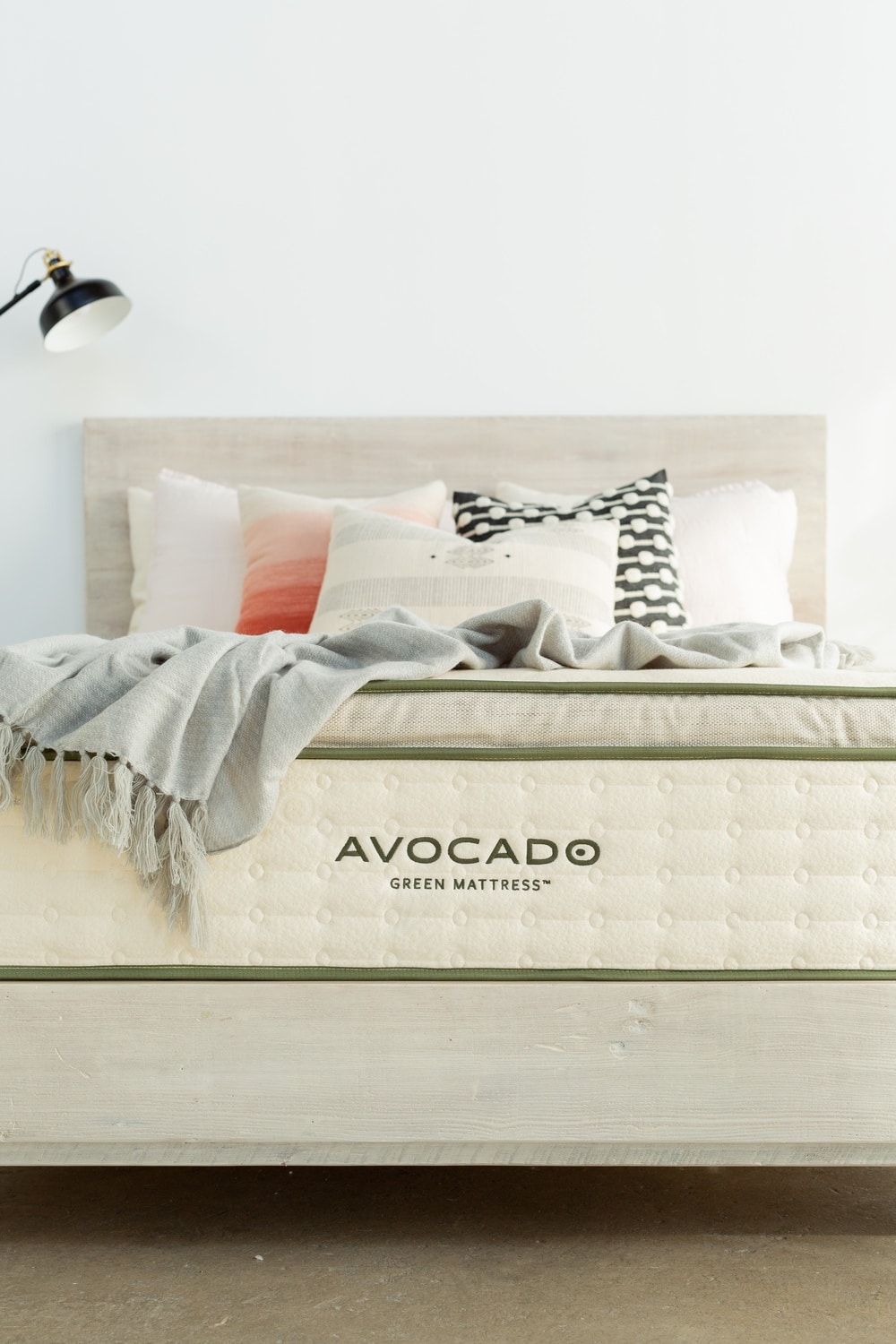 Modern bedroom with an Avocado Green Mattress on a wooden bed frame, styled with chic pillows and a throw