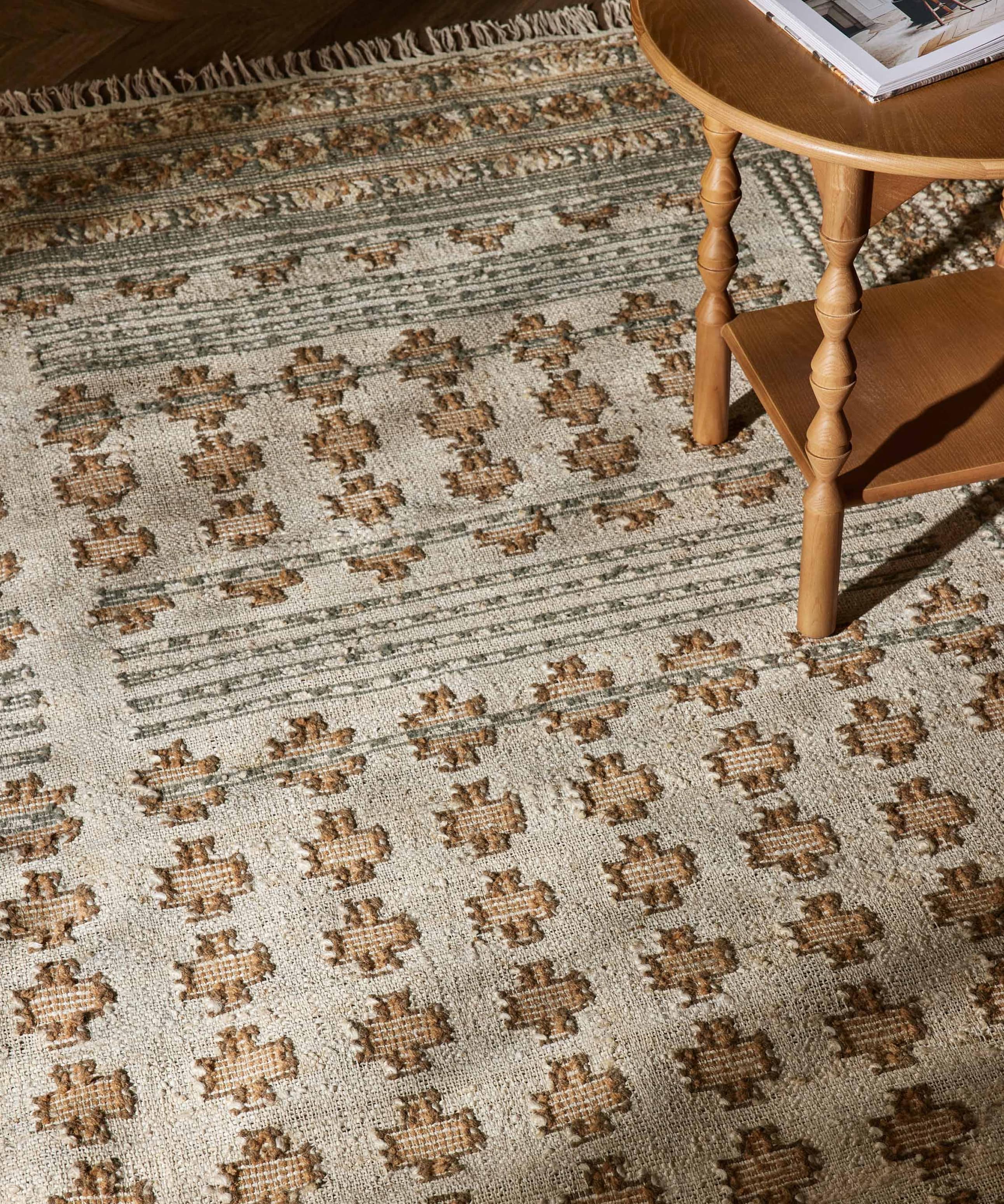 Patterned rug with a wooden chair leg and a corner of a table visible