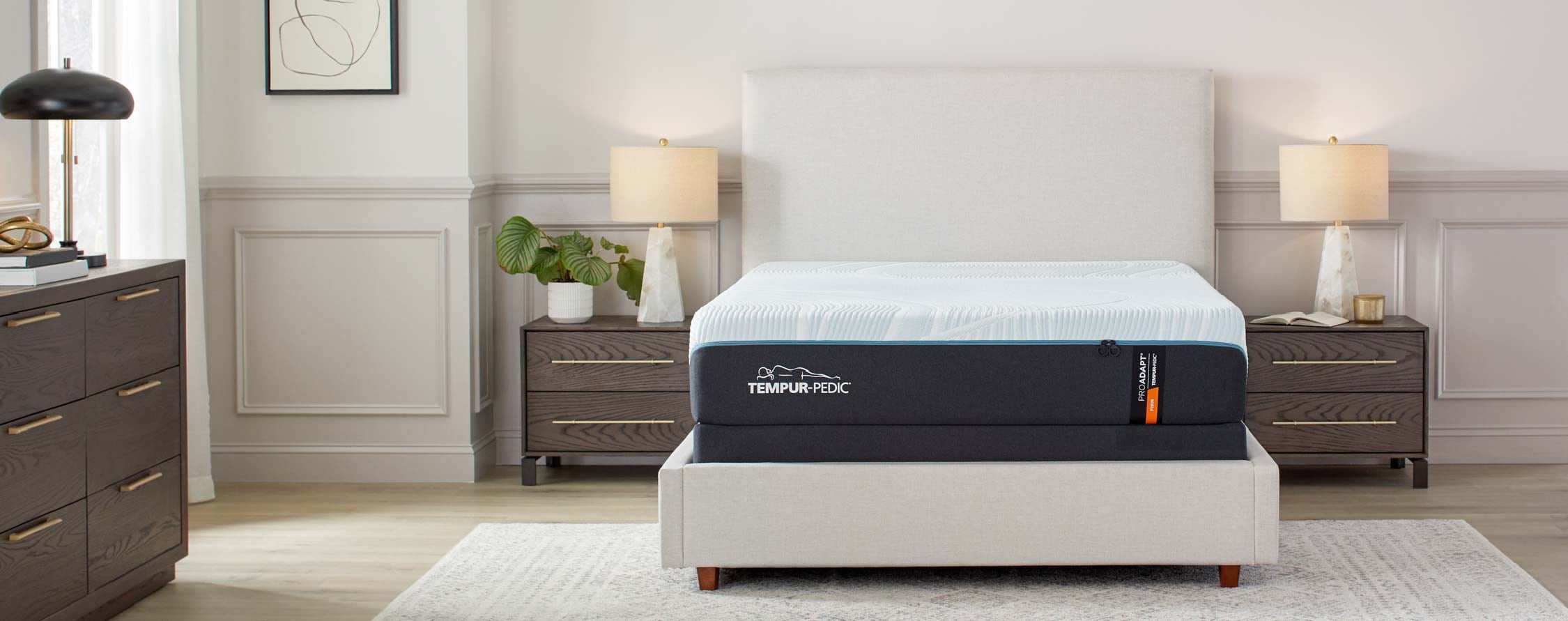 Modern bedroom with a neatly made white bed, two nightstands, lamps, and a dresser
