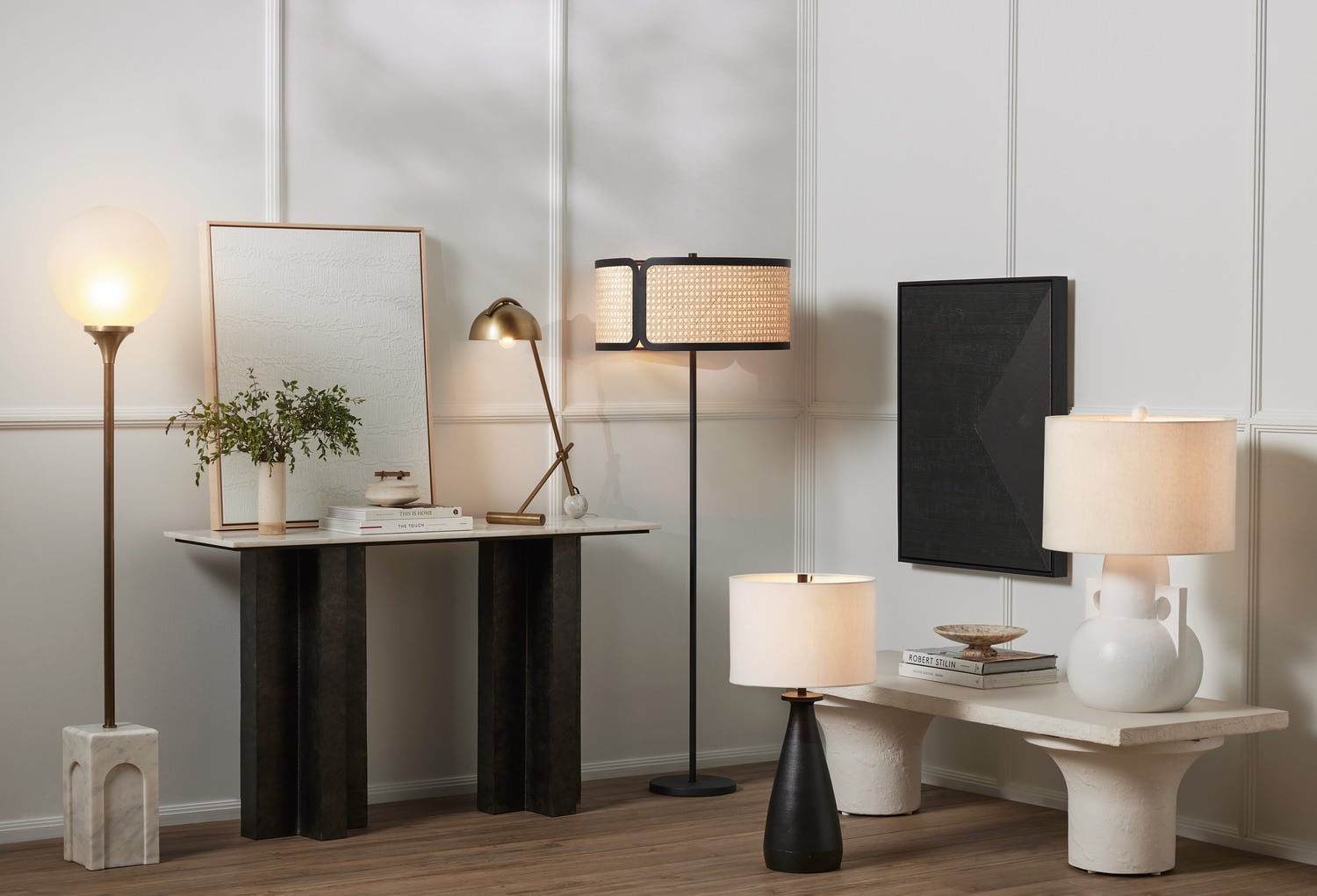 Modern interior design with various lamps, a console table, mirror, and plant. Neutral color palette