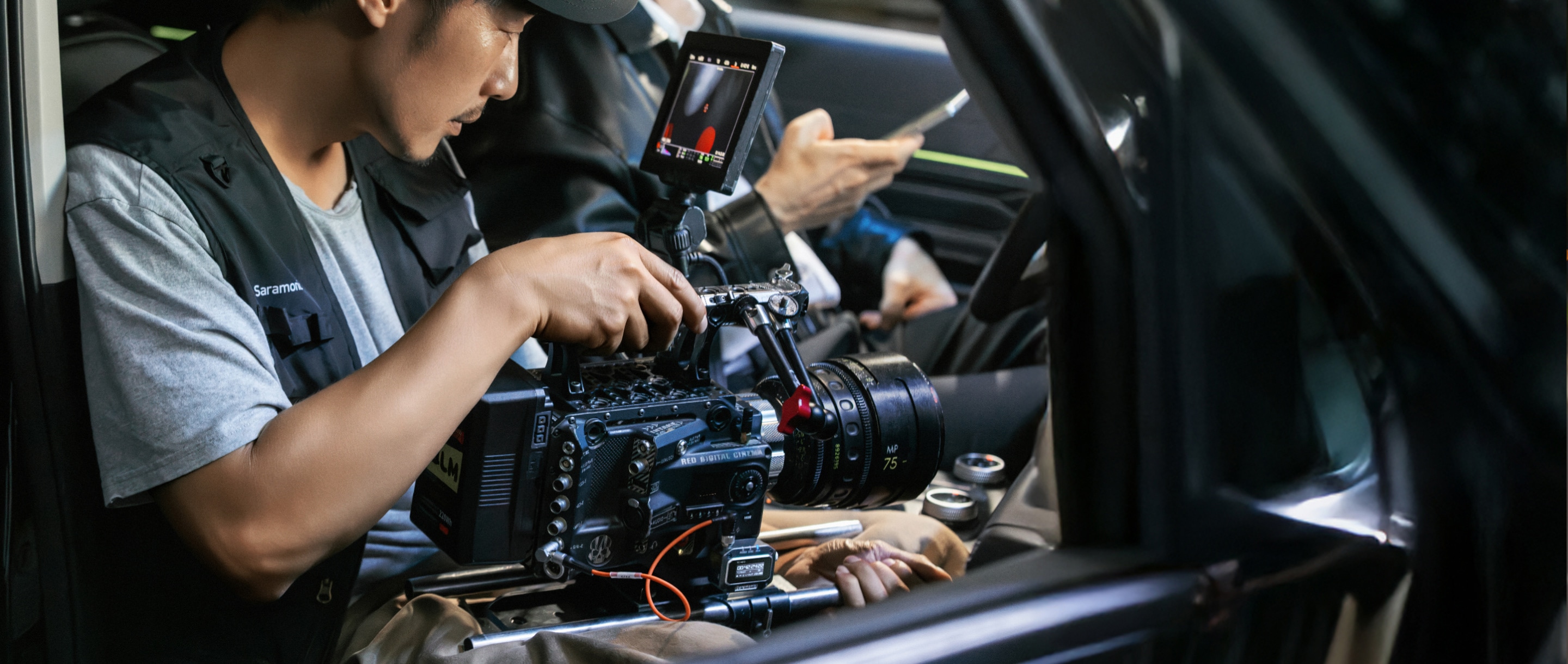 Man filming with a camera inside a car