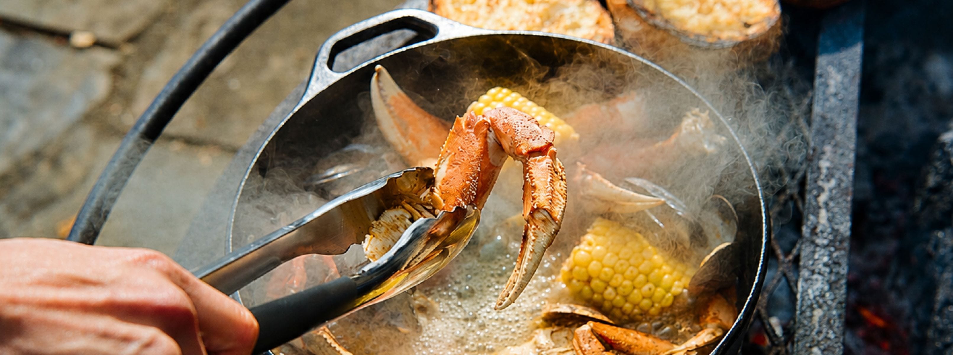 seafood boil in cast iron dutch oven on outdoor grill