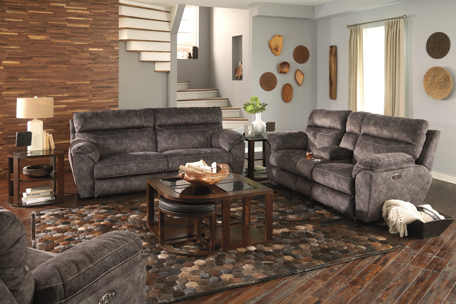 Modern living room with gray sofas, wooden coffee table, and decorative wall plates