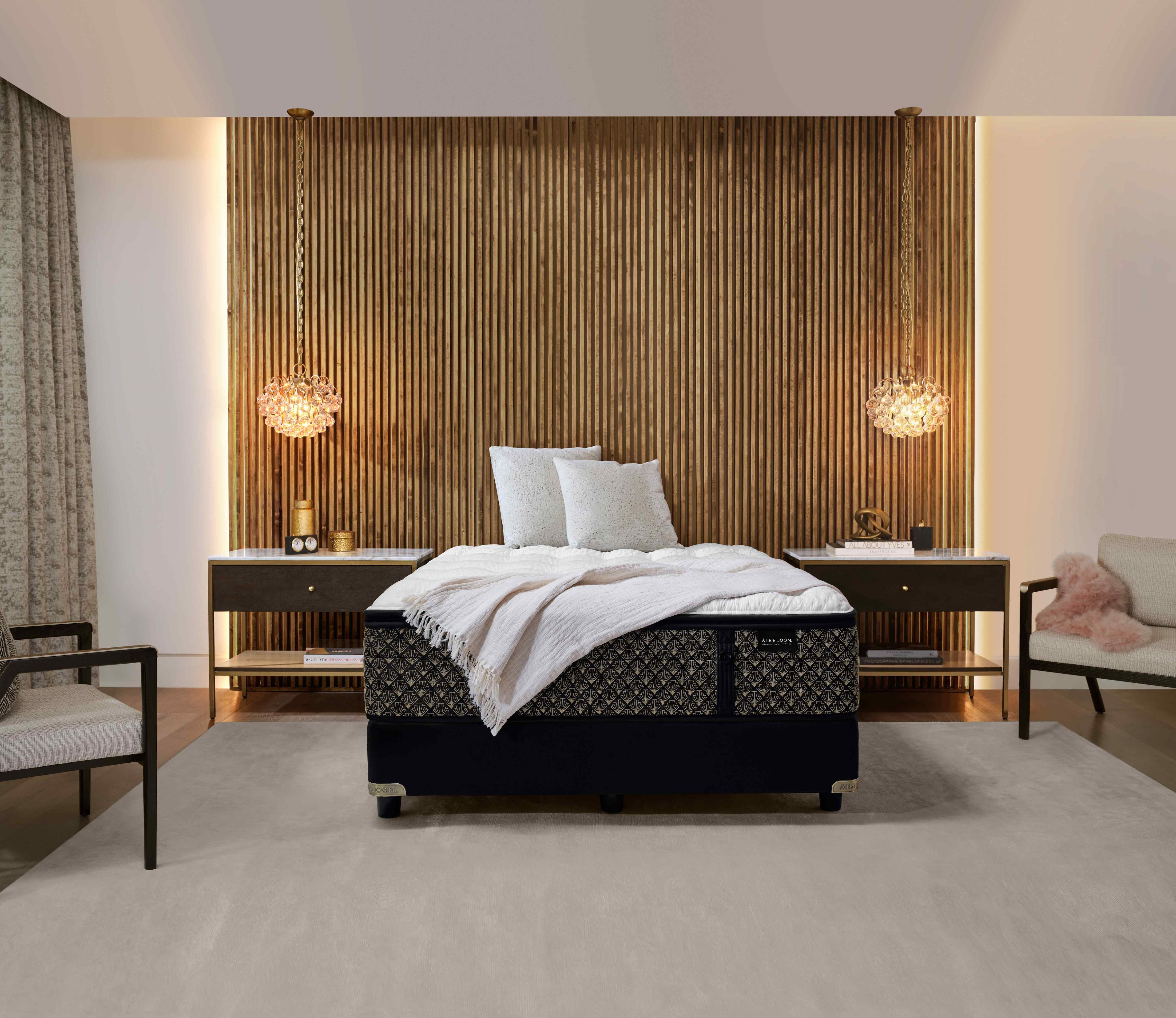 Modern bedroom with a patterned bed, wood panel walls, and soft lighting