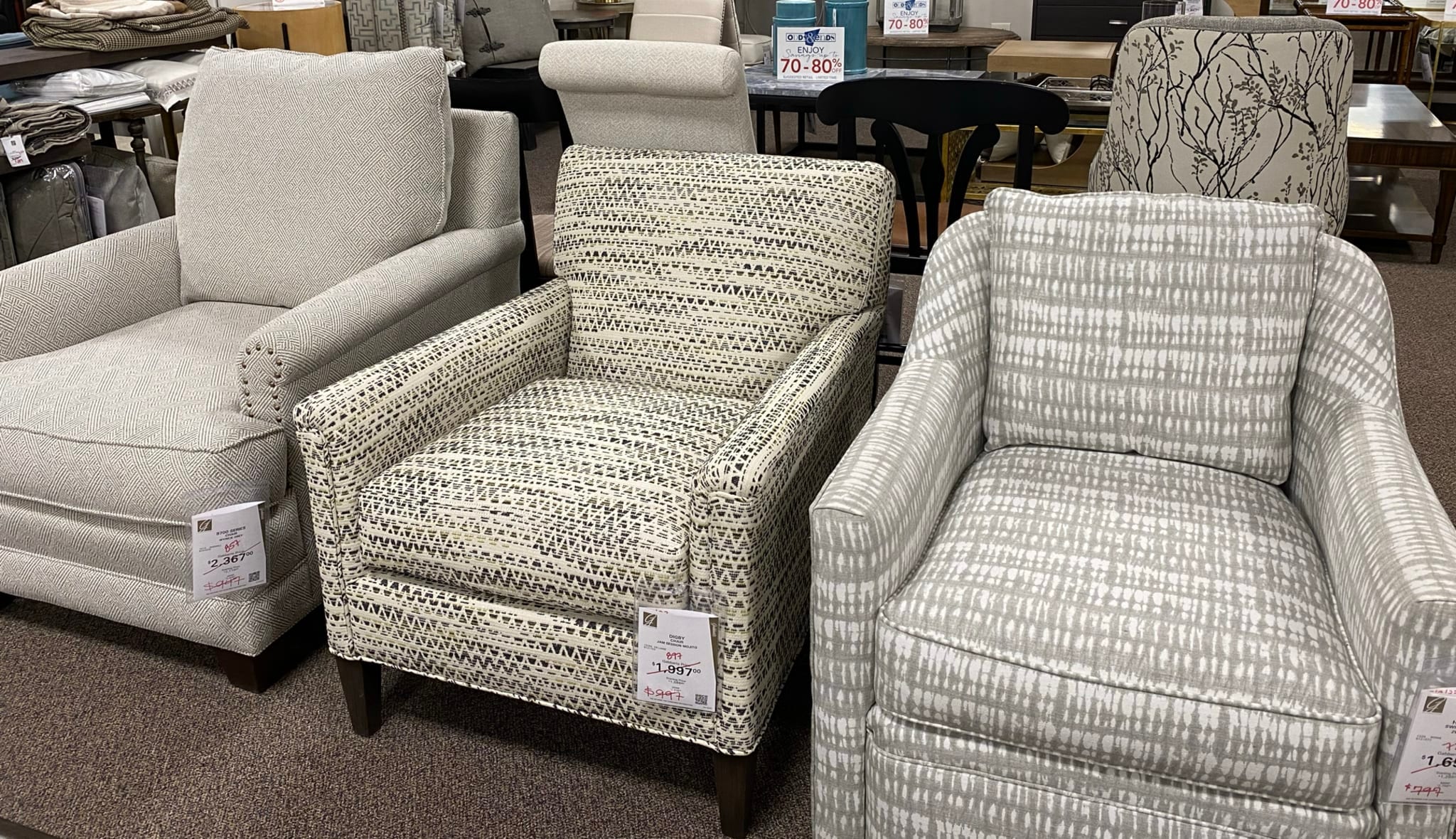 Various patterned armchairs and sofas displayed in a furniture store
