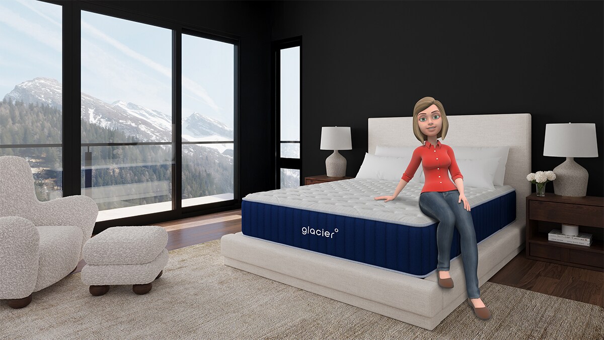 Ali sitting on a Glacier Mattress in a modern bedroom with large windows showing a snowy mountain landscape