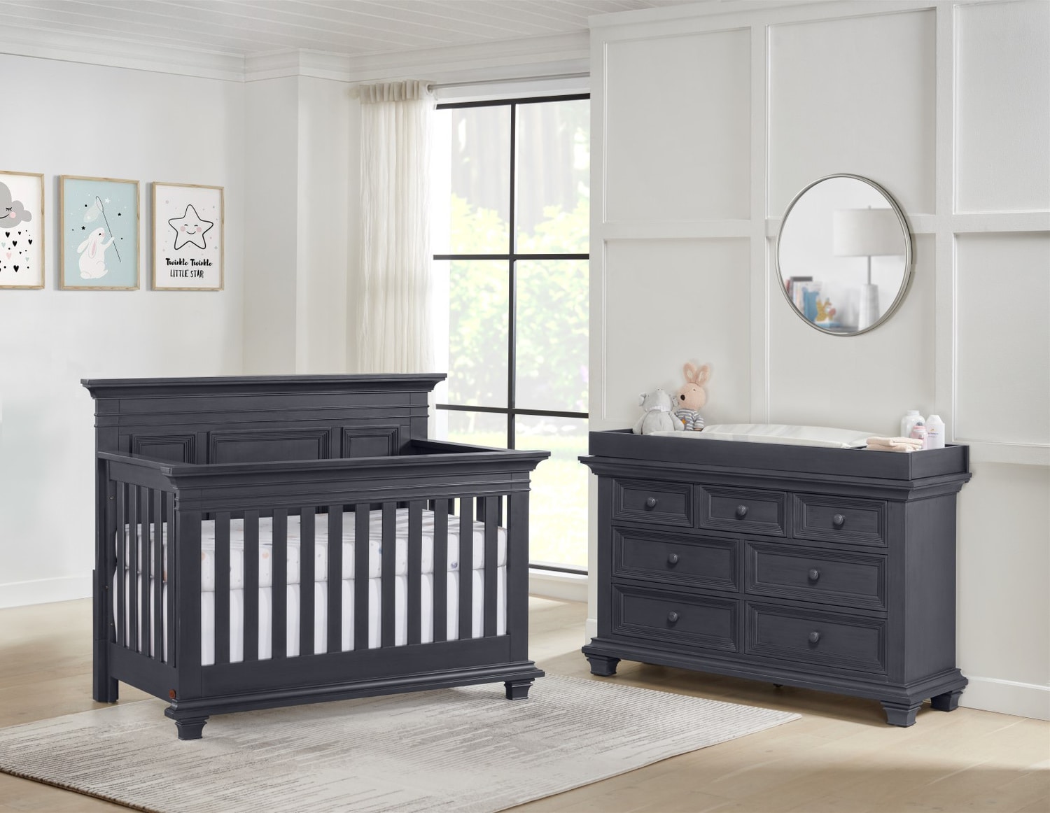 Modern nursery room with a black crib and dresser in a bright room