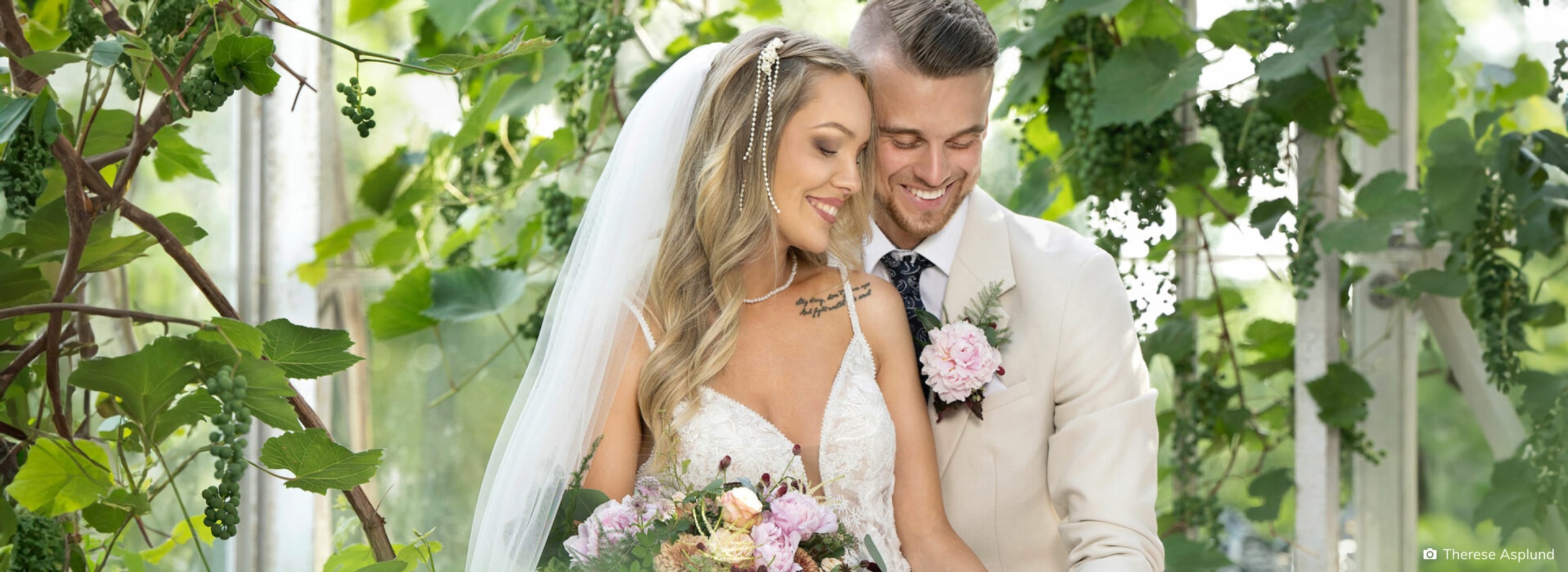 Bride and groom smiling and walking in a lush garden