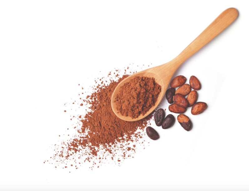 Cuillère en bois avec une pincée de poudre de cacao